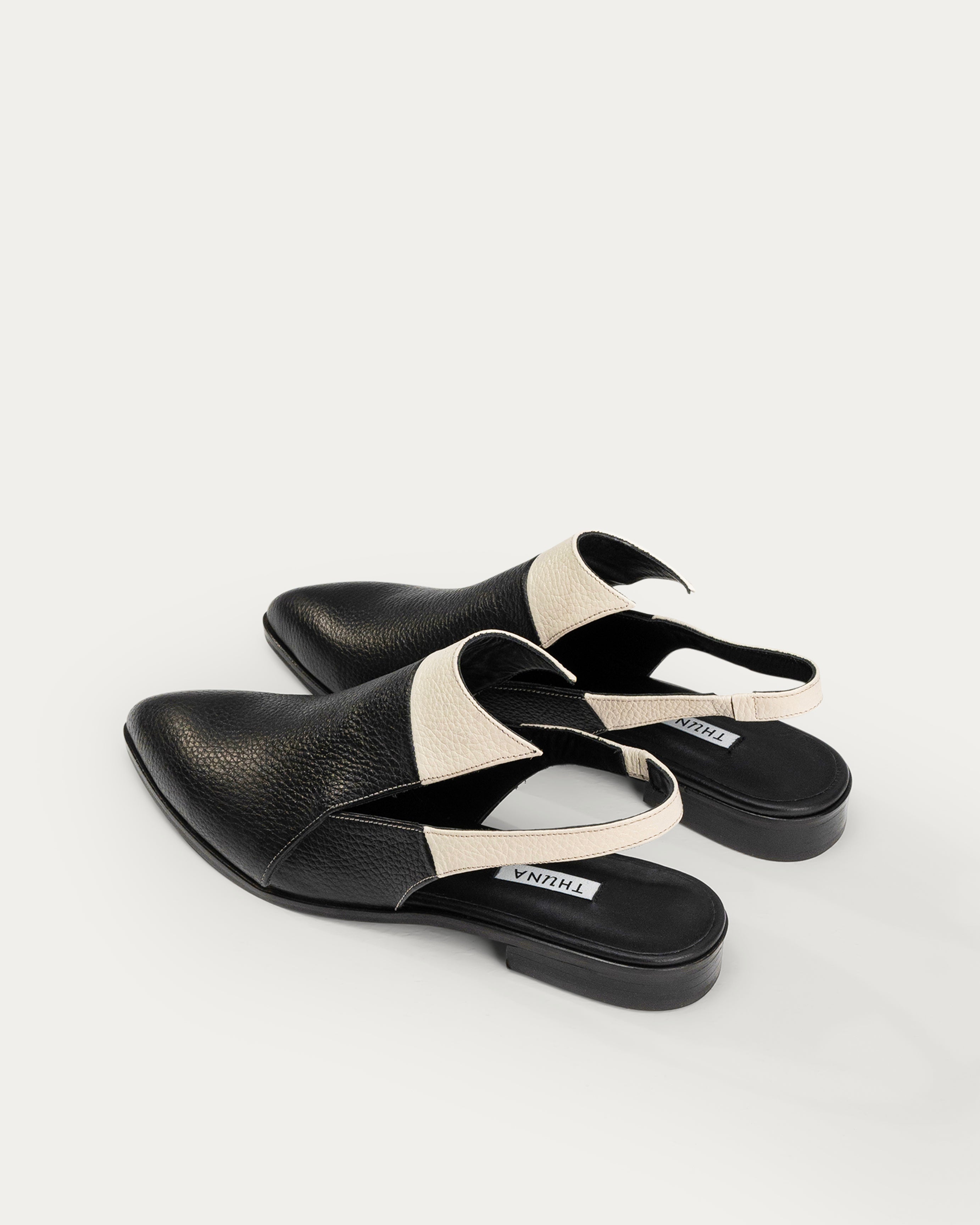 Black slingback shoes with white accents on a light gray background - THUNA Shoes - Kuwait - KSA