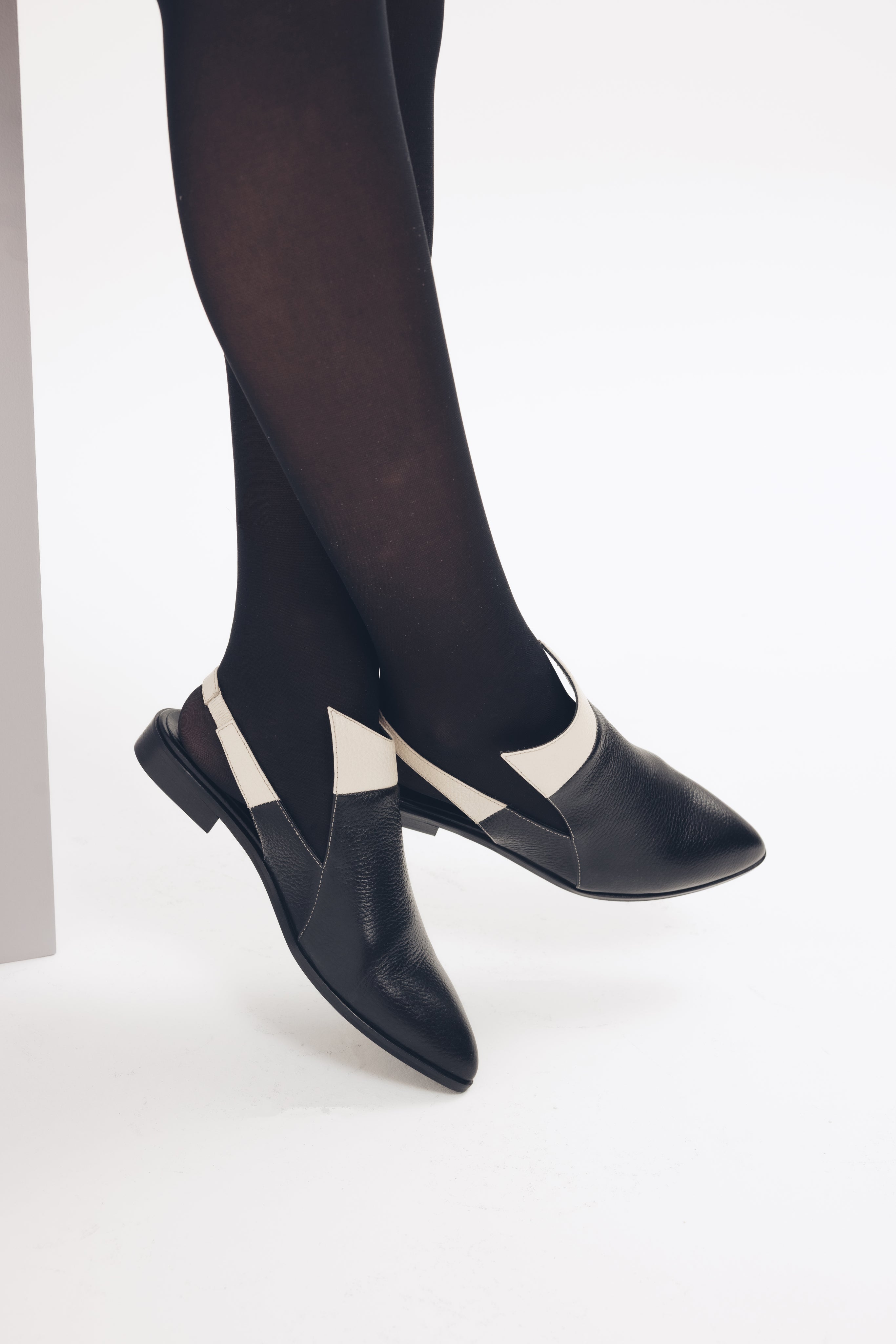 Black slingback shoes with white accents on a light gray background - THUNA Shoes - Kuwait - KSA